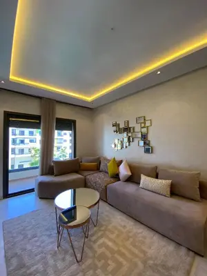 a living room with a couch and a table at Natura Appartement Pool View by 7AV Hotels in Mohammedia