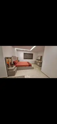 a living room with a red bed and a couch at Suites au sein d'une Villa au centre ville de Rabat in Rabat