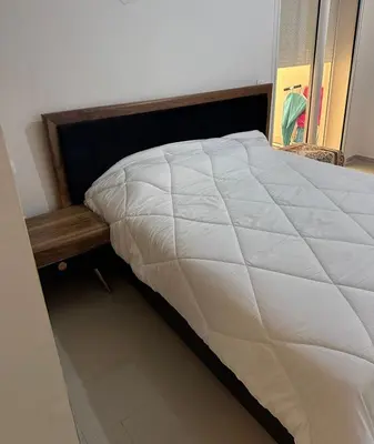 a bedroom with a large white bed with a wooden headboard at Studio Seaside Resort Casablanca in Dar Hamida
