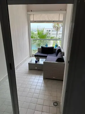 a living room with a couch and a large window at Studio Seaside Resort Casablanca in Dar Hamida