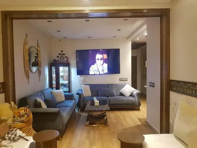 a living room with a couch and a tv at Appartement Prestige à Rabat Océan - 2min de la Plage in Rabat