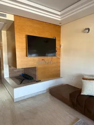 a living room with a flat screen tv on a wall at Appartement Souissi avec 3 chambres in Rabat