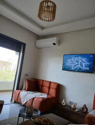 a living room with a couch and a fan at Zen garden by sea in Aïn Harrouda