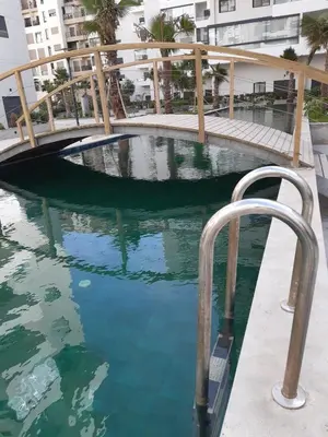 a swimming pool with a hand rail in the water at Zen garden by sea in Aïn Harrouda