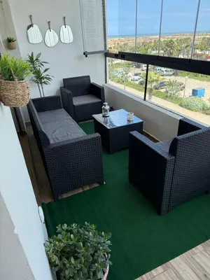 a balcony with wicker chairs and a table at Zen garden by sea in Aïn Harrouda