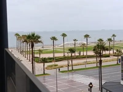 a view of a parking lot with palm trees and the ocean at Studio Luxe avec Vue sur la Corniche in Casablanca