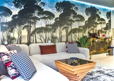 a living room with a couch and a mural of trees at Studio Luxe avec Vue sur la Corniche in Casablanca