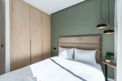 a bedroom with a large white bed with wooden cabinets at Studio palmier TR3 in Casablanca