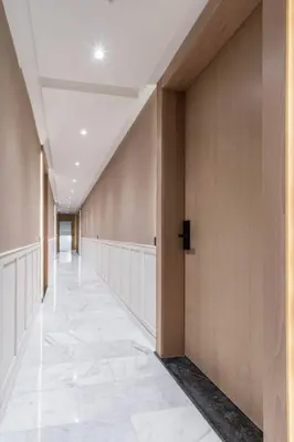 a hallway of a building with wooden walls and a white tile floor at Studio palmier TR3 in Casablanca