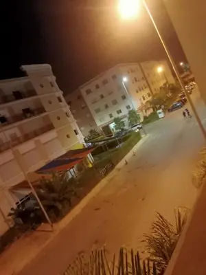 an empty street in front of a building at night at Casa sabir in Temara