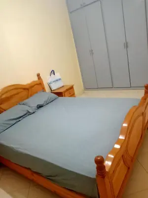 a bedroom with a wooden bed and white cabinets at Casa sabir in Temara
