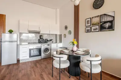 a kitchen with a table and chairs and a refrigerator at Cozy studio 5 min Casa port Parking Netflix in Casablanca