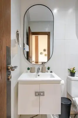 a bathroom with a white sink and a mirror at Cozy studio 5 min Casa port Parking Netflix in Casablanca