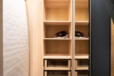 a closet with wooden shelving with two cars in it at El home del belbala in Casablanca