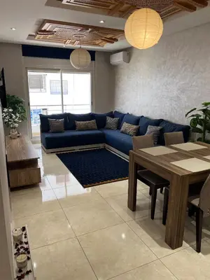 a living room with a blue couch and a table at Appartement fraichement rénové à Agdal in Rabat