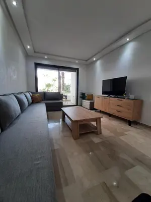 a living room with a couch and a flat screen tv at Mansouria Beach Resort in Mohammedia