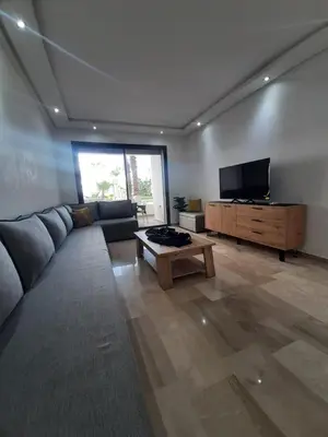 a living room with a couch and a flat screen tv at Mansouria Beach Resort in Mohammedia
