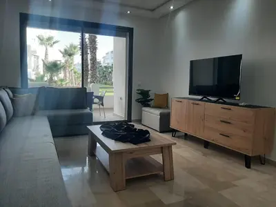 a living room with a couch and a flat screen tv at Mansouria Beach Resort in Mohammedia