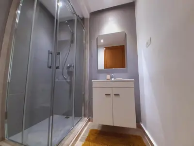 a bathroom with a shower and a sink and a mirror at Mansouria Beach Resort in Mohammedia