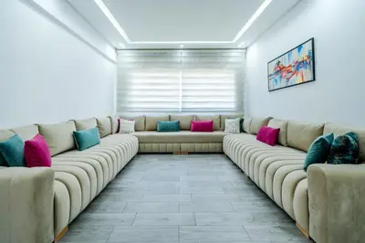 a living room with a long couch with colorful pillows at Luxury cozy apartment in Casablanca