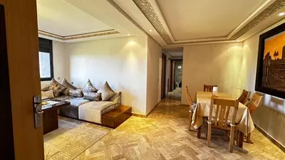 a living room with a couch and a table at Appartement avec piscine près de la mer in O Ben Slimane