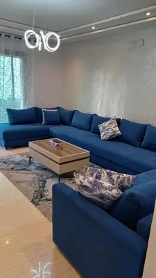 a living room with a blue couch and a coffee table at newly and fully furnished apprt in Sidi Rahal