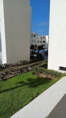 a view of a building with a green lawn at newly and fully furnished apprt in Sidi Rahal