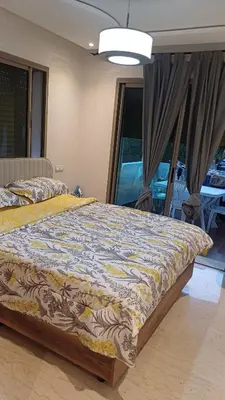 a bedroom with a bed with a comforter on it at newly and fully furnished apprt in Sidi Rahal