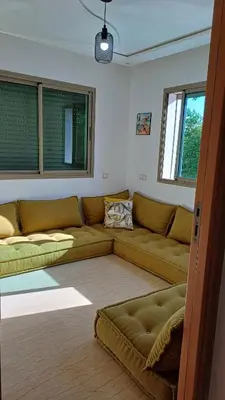 a living room with two couches and two windows at newly and fully furnished apprt in Sidi Rahal