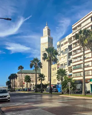 a large building with a clock tower in a city at Apartment Casa Marina - Borgone, Ocean & Hassan II Views in Casablanca