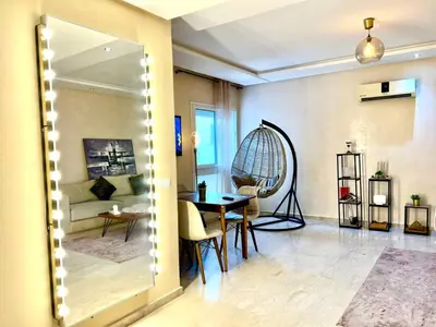 a living room with a table and a couch at Apartment Casa Marina - Borgone, Ocean & Hassan II Views in Casablanca