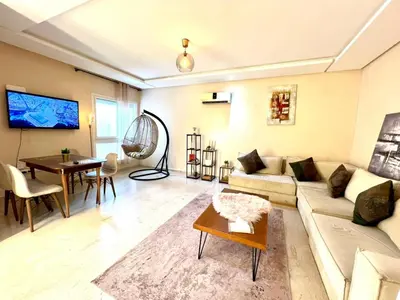 a living room with a couch and a table at Apartment Casa Marina - Borgone, Ocean & Hassan II Views in Casablanca