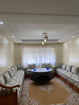 a living room with a couch and a table at appartement cité marine plage 5min in O Ben Slimane