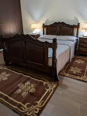 a bedroom with a bed and two rugs at appartement cité marine plage 5min in O Ben Slimane