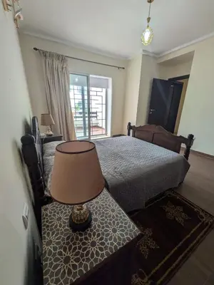 a bedroom with a bed and a table with a lamp at appartement cité marine plage 5min in O Ben Slimane