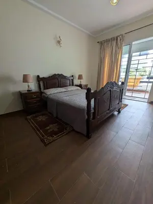 a bedroom with a bed and a large window at appartement cité marine plage 5min in O Ben Slimane