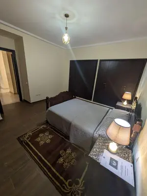 a bedroom with a bed and a table with a lamp at appartement cité marine plage 5min in O Ben Slimane