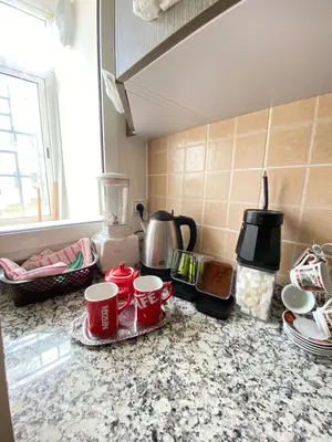 a kitchen counter with three cups and a blender at appartement cité marine plage 5min in O Ben Slimane