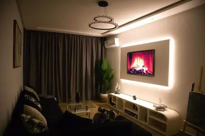 a living room with a couch and a tv on the wall at KST Home-Heaven Beach Sidi Rahal in Sidi Rahal
