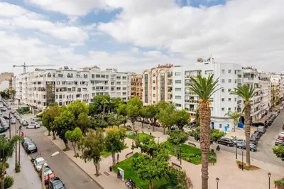 a city with buildings and a street with palm trees at Luxury Garden View Apartment Private Floor in Casablanca