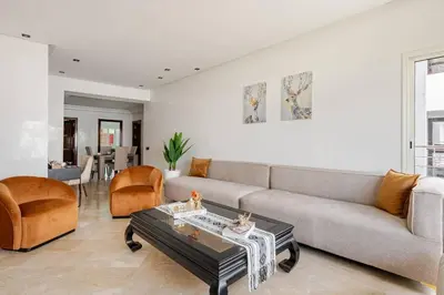 a living room with a couch and a table at Luxury Garden View Apartment Private Floor in Casablanca