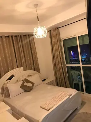 a bedroom with a bed and a window with a chandelier at Salam Beach in Pont Blondin