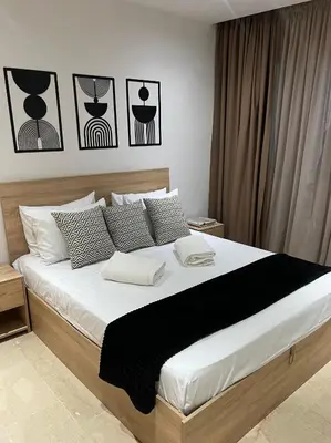 a bedroom with a large bed with black and white pillows at Appartement de luxe vue sur mer in Bouznika