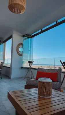 a living room with a table and a view of the ocean at Appartement de luxe vue sur mer in Bouznika