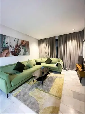 a living room with a green couch and a table at A102 Studio cosy & chic in Casablanca