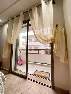 a room with a glass door with a window at Marbella beach in Mansouria