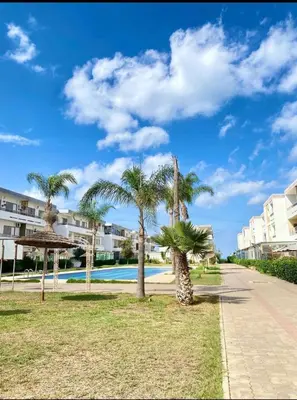 a group of palm trees next to a swimming pool at Marbella beach in Mansouria