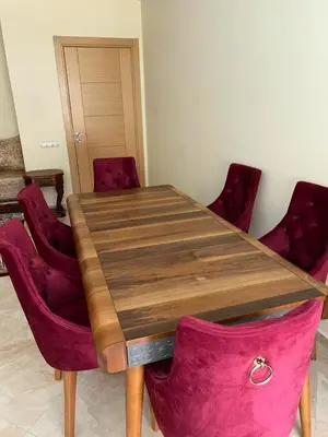 a wooden table with red chairs in a room at Kettani Shems Bouznika in Bouznika