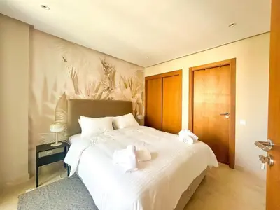 a bedroom with a large white bed with towels on it at Small Cozy Nest in Quiet Area - Central with Balcony in Casablanca