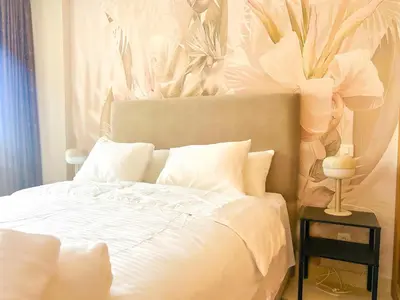a bedroom with a white bed with a flower headboard at Small Cozy Nest in Quiet Area - Central with Balcony in Casablanca